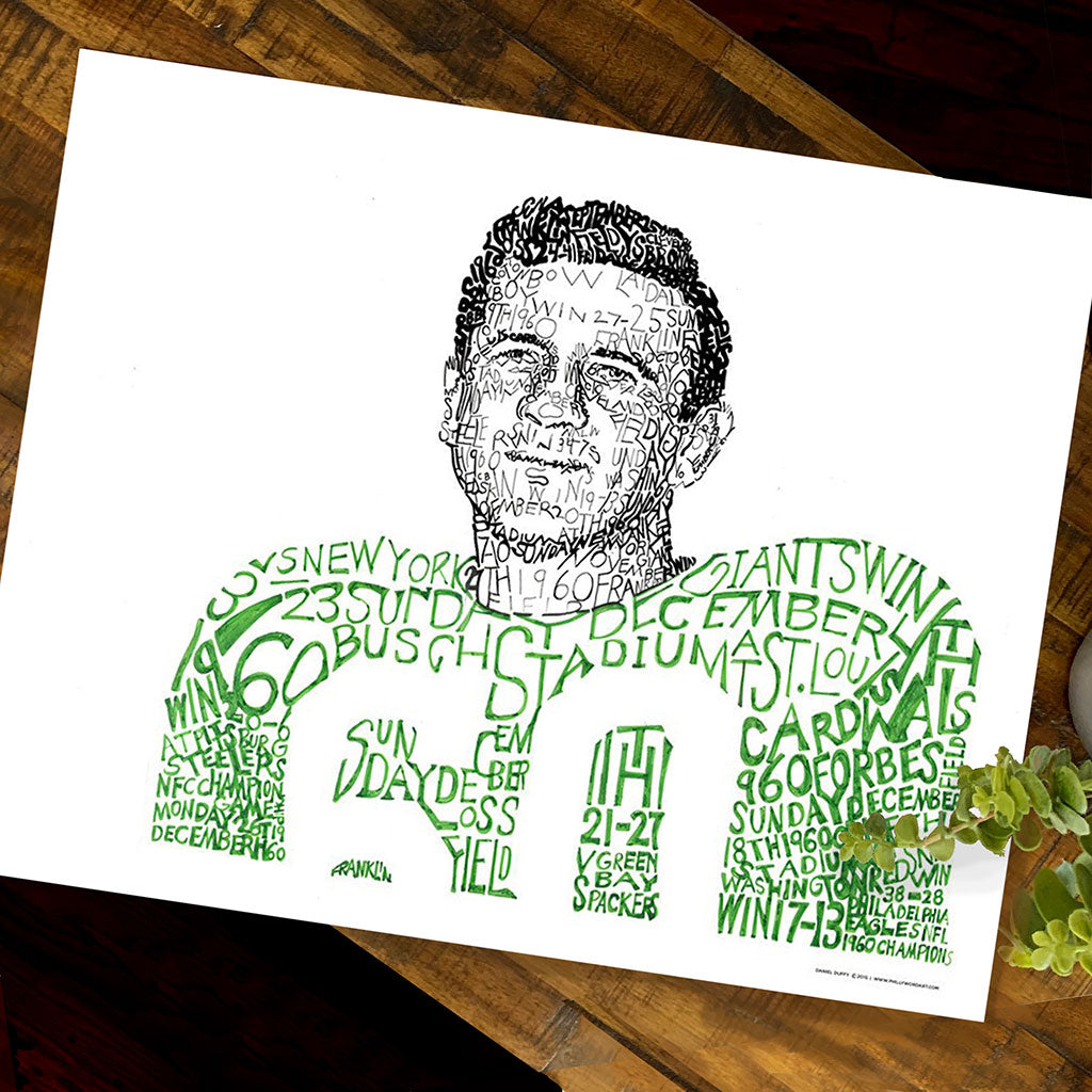 Unframed handwritten word art of 1960 Philadelphia Eagle Chuck Bednarik lies flat on wood table next to small plant.